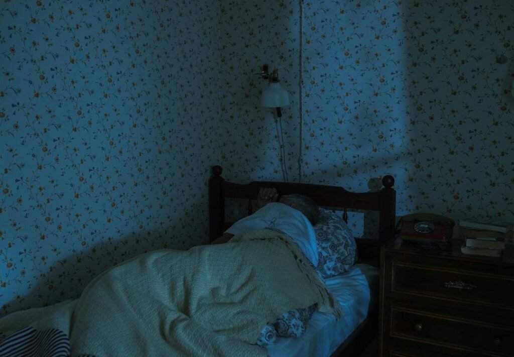 qualidade de sono - homem dormindo em sua cama com vários travesseiros e um coberto amarelo