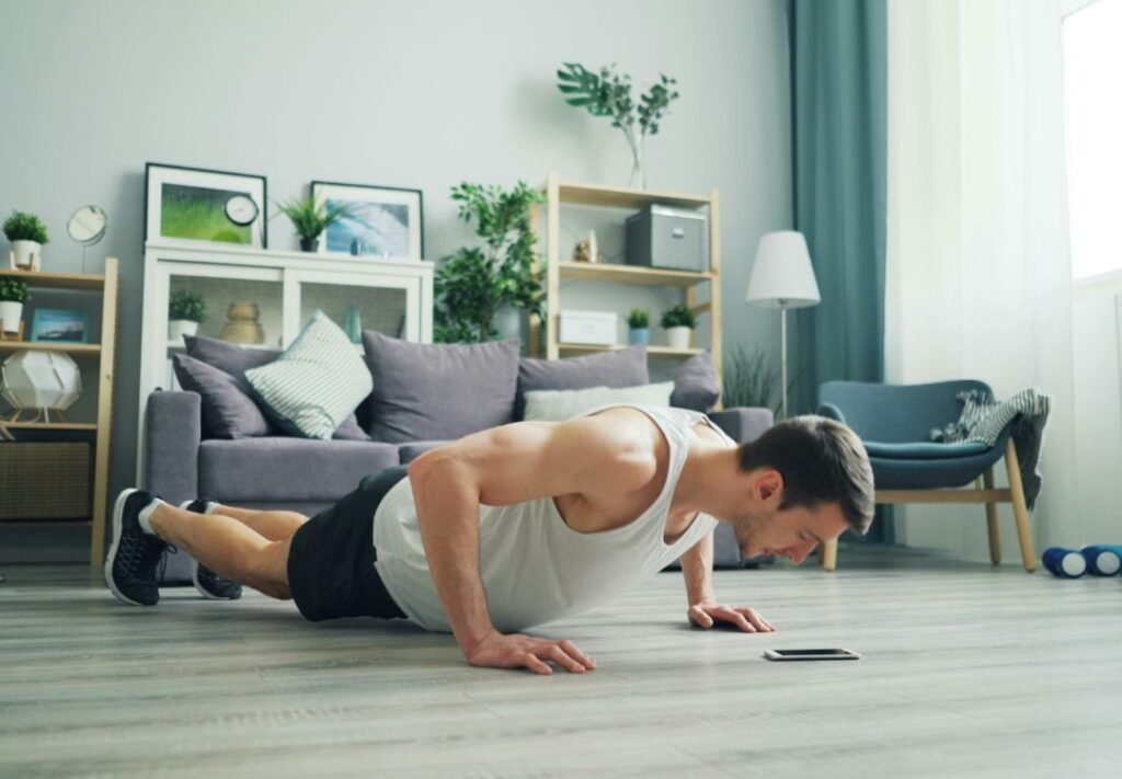 vida fitness em casa - homem realizando flexão na sala de sua casa